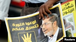 A member of the Muslim Brotherhood holds a poster of ousted Islamist leader Muhammad Morsi.