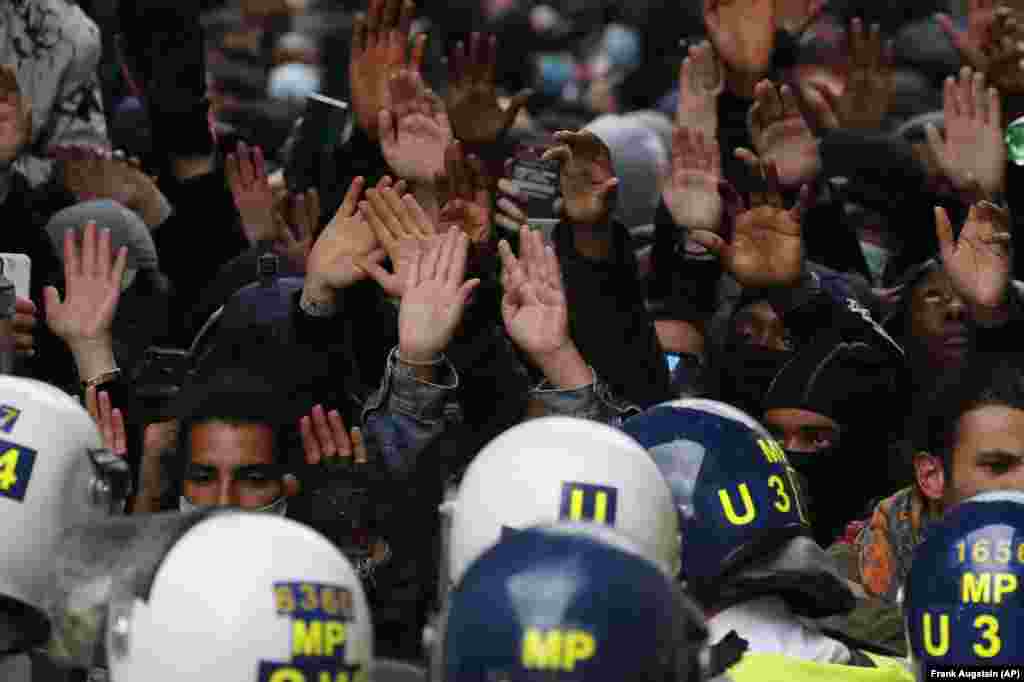 Лицем до лиця: учасники протесту Black Lives Matter із піднятими угору руками дивляться ув очі лондонським поліцейським. Велика Британія, 7 червня 2020 року