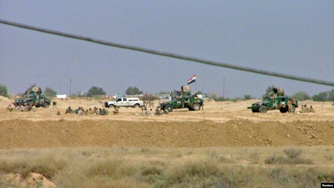 Iraqi security forces are seen outside Camp Ashraf after deadly fighting with residents in April 2011.