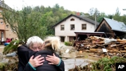 „Bine că am scăpat cu viață”. O femeie în vârstă este îmbrățișată de fiică după ce a fost evacuată la Jesenik, în Cehia, una din localitățile cele mai greu încercate de inundațiile din weekend.