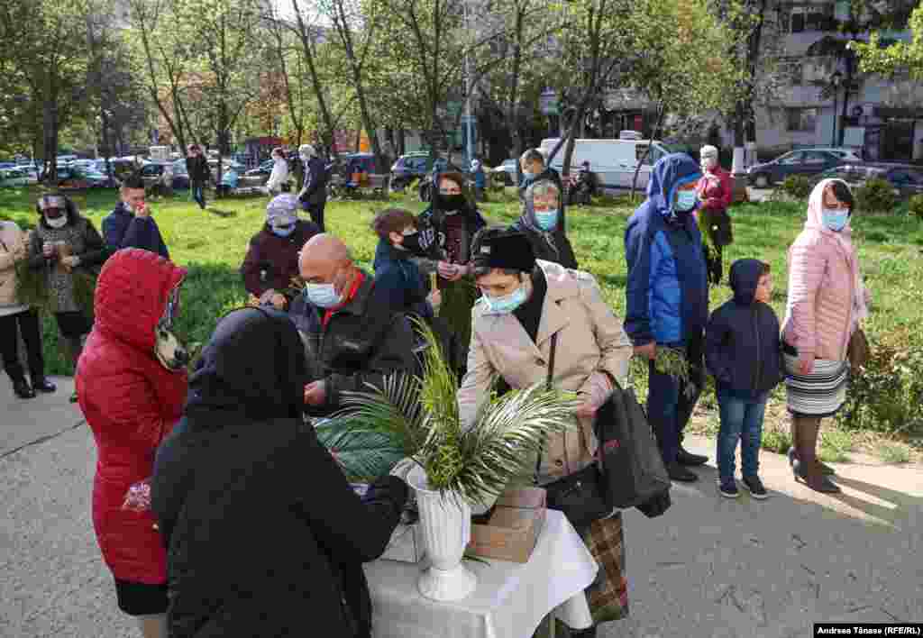 Slujba de Florii celebrată de credincioși în exteriorul Bisericii Sf. Arhangheli Mihail și Gavriil din București.