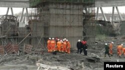 Hytaýda gurluşyk heläkçiliginiň bolan ýerinde halas ediş gullugynyň işgärleri gözleg-agtaryş işlerini geçirýärler. 24-nji noýabr, 2016 ý.