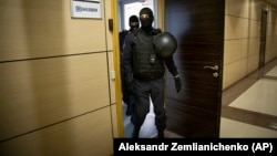 Russian police are shown raiding the offices of Aleksei Navalny's Anti-Corruption Foundation in Moscow on July 17.