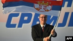 Predsjednik Srbije Aleksandar Vučić maše srpskom zastavom tokom mitinga u Beogradu 27. juna 2026. godine
