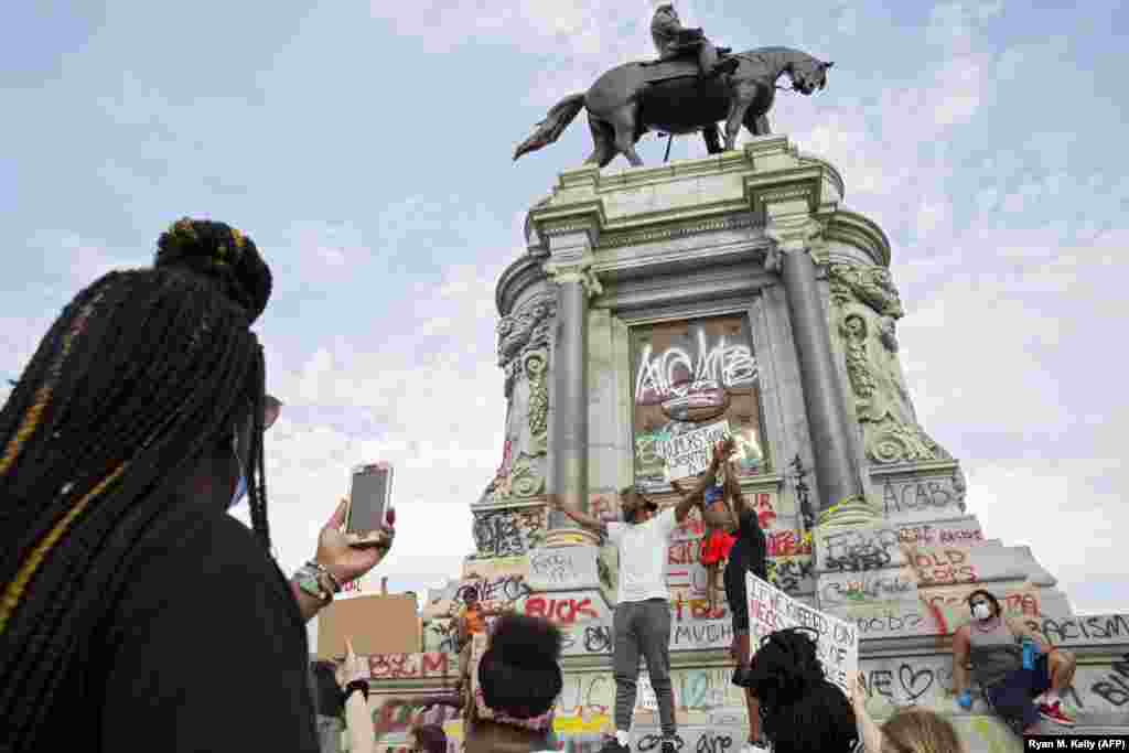 Oamenii se adună în jurul monumentului generalului Robert E. Lee, aflat la conducerea armatei sudiste în timpul războiului de secesiune,&nbsp; de pe Monument Avenue din Richmond, Virginia, la 4 iunie 2020, pe fondul continuării protestelor față de moartea lui George Floyd pe când se afla custodia poliției. La începutul zilei, guvernatorul de Virginia, Ralph Northam, a anunțat planurile de a îndepărta statuia generalului confederat, îndrumând Departamentul de Servicii Generale să o înlăture &bdquo;cât mai curând posibil&quot;.