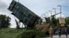FILE PHOTO: Ukrainian service members walk next to a launcher of a Patriot air defence system an undisclosed location in Ukraine