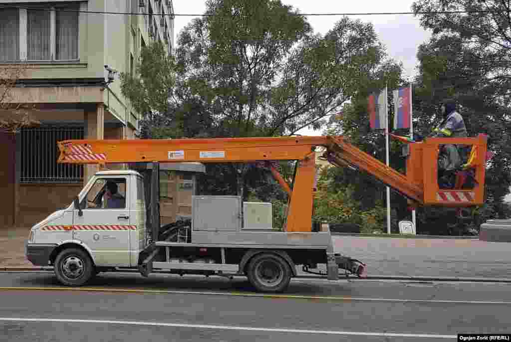 Radnik komunalne službe postavlja zastavicu duginih boja