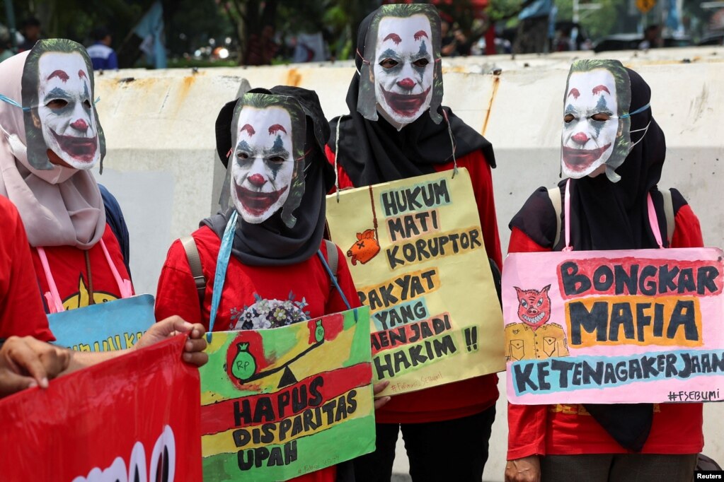 Punëtorë me maska të personazhit Xhoker gjatë një tubimi në Xhakartë, Indonezi.
