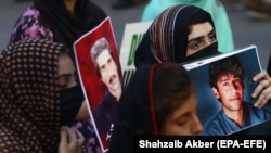 Relatives hold portraits of disappeared family members during a protest in Karachi on August 30.