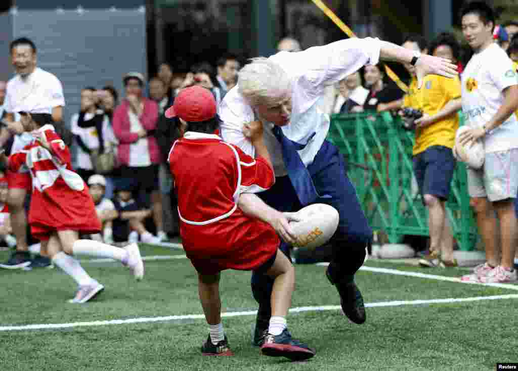 London Mayor Boris Johnson collides with 10-year-old Toki Sekiguchi during a game of street rugby with a group of Tokyo children while on a trade mission trip to Japan on October 15.(Reuters/Issei Kato)