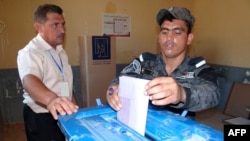 An Iraqi policeman casts his ballot in Fallujah, in Anbar Province, on June 17, as security forces vote early.