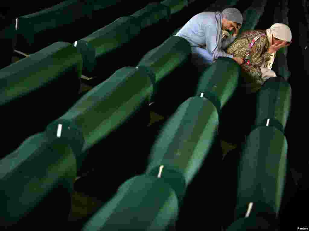 Two Bosnian Muslim women cry over a coffin with remains of their relative in a factory hall in Potocari where 610 victims of Srebrenica massacre wait for the funeral. Two Bosnian Muslim women cry over a coffin July 10, 2005 with remains of their relative in a factory hall in Potocari where 610 victims of Srebrenica massacre wait for the funeral. Tens of thousands of family members, foreign dignitaries and guests are expected to attend a ceremony in Srebrenica on July 11 marking the 10th anniversary of the massacre in which Serb forces killed up to 8,000 Muslim men and boys. 610 identified victims will be buried at a memorial cemetery during the ceremony, their bodies found in some 60 mass graves around the town. More than 1,300 Srebrenica victims are already buried there. REUTERS/Damir Sagolj 