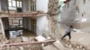 An Afghan boy passes by a collapsed house after flash flood in the west of Kabul on April 16.