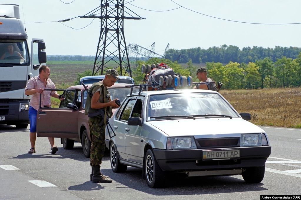 Một quân nhân Ukraine đang kiểm tra giấy tờ tại một trạm kiểm soát gần Maryinka vào tháng 8 năm 2014.