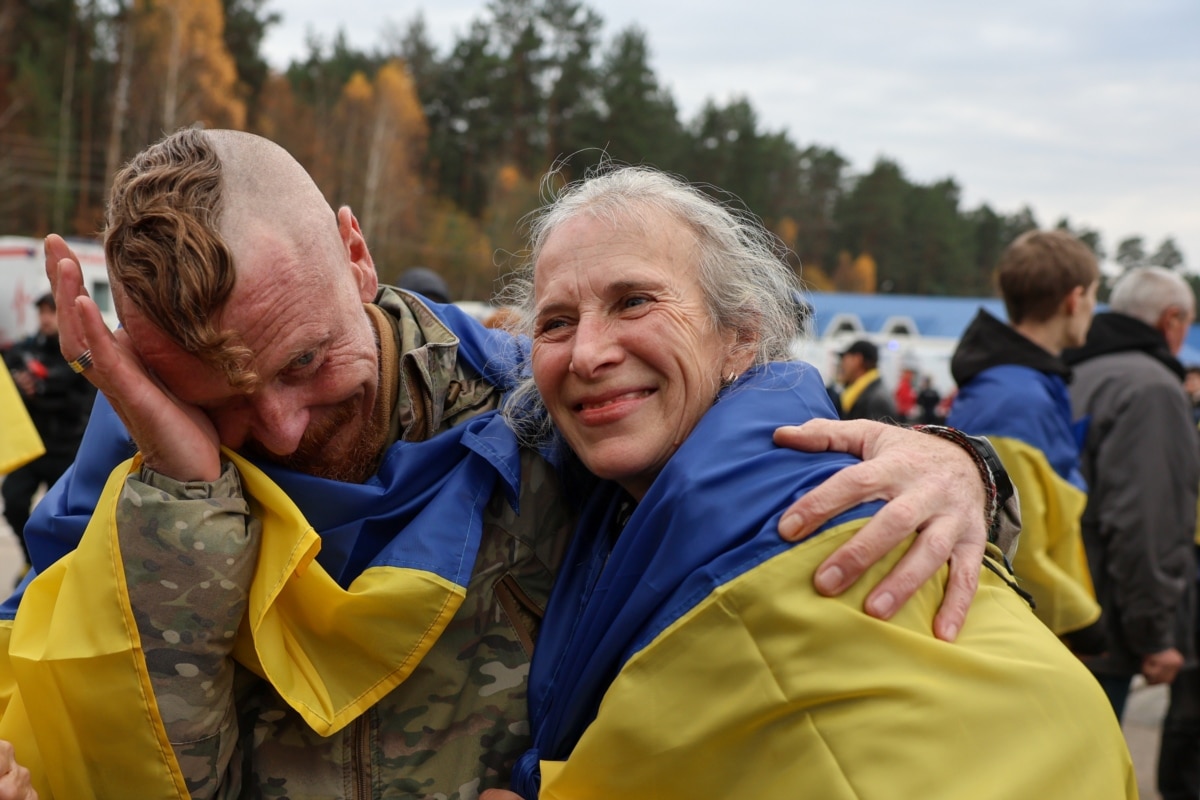 Український військовослужбовець Дмитро витирає сльози, обіймаючи свою дружину Ларису після її евакуації з їхнього рідного міста, Олешки, 31 жовтня 2026 року