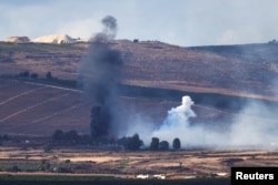 Smoke rises above Lebanon following an Israeli strike, amid the ongoing cross-border hostilities between Hizballah and Israeli forces, as seen from Israel's border with Lebanon.