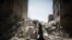 A Syrian woman walks past a destroyed building while reaching a food distribution centre in Aleppo earlier this month. 