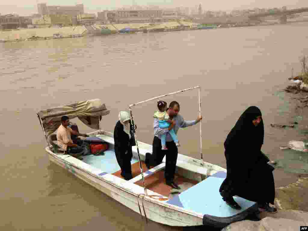 Ірацкая сям'я выходзіць з лодкі на бераг ракі Тыгр у Багдадзе. Шмат каму з іракцаў даводзіцца перапраўляцца праз раку на лодках, бо значная частка мастоў заблякаваная зь меркаваньняў бясьпекі