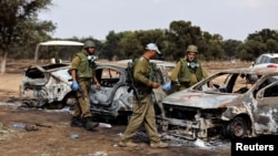 Izraeli katonák vizsgálják a fesztiválozók kiégett autóit a Hamász által elkövetett támadás helyszínén, Izrael és a Gázai övezet határának közelében 2023. október 13-án