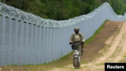FOTO DE ARHIVĂ: Un membru al unității speciale a Gărzii de Frontieră din Letonia patrulează de-a lungul gardului de la granița dintre Letonia și Belarus, în apropiere de Robeznieki.