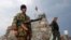 Pro-Russian separatists patrol beside a destroyed war memorial near the city of Donetsk on August 28. Despite continued fierce fighting in eastern Ukraine, most interested parties seem to be going out of their way to avoid calling the conflict a "war." 