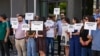 Pjesëtarë të organizatave të shoqërisë civile mbajnë në duar pankarta në shenjë proteste kundër moskonstituimit të Kuvendit të Kosovës, pranë hyrjes së Kuvendit në Prishtinë, 25 mars.