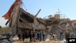 People gather near the ruins of a hospital supported by Doctors Without Borders (MSF) near Maaret al-Numan, in Syria's northern province of Idlib on February 15.