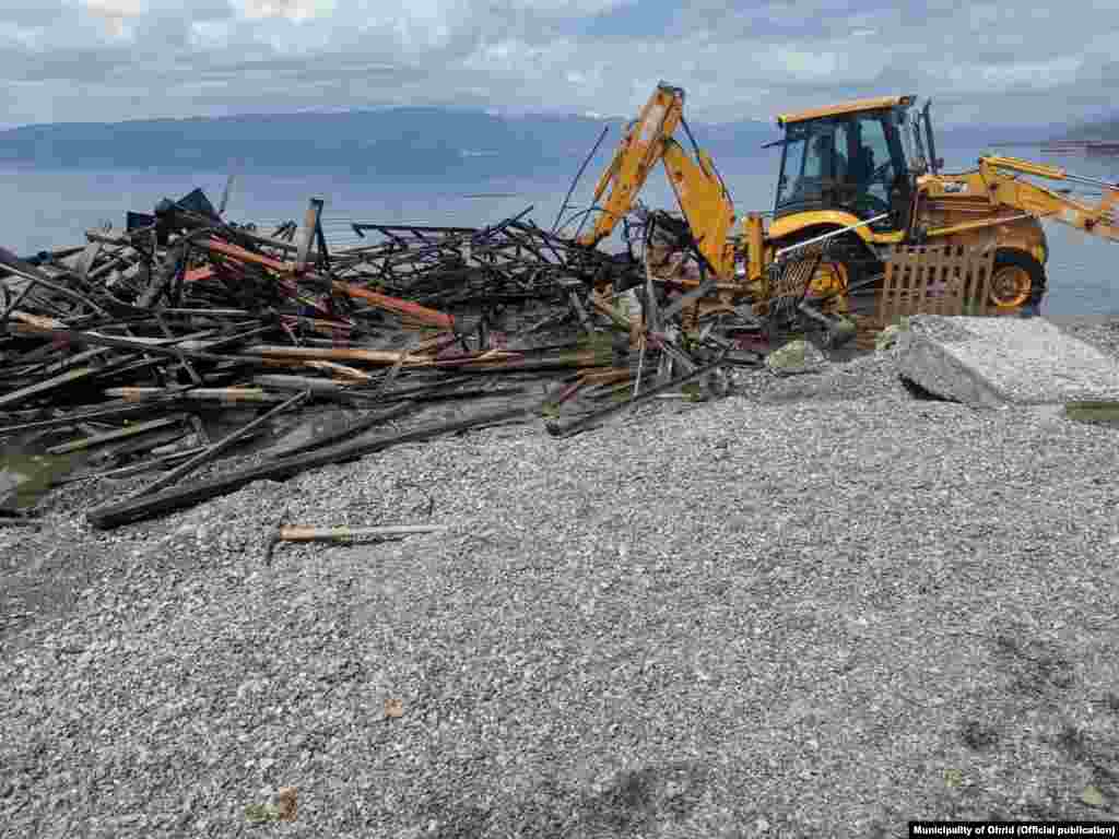 Një fotografi nga maji i hershëm shfaq makineri të rënda duke rrënuar një strukturë të ndërtuar ilegalisht në brigjet e Liqenit të Ohrit, në Maqedoninë e Veriut.