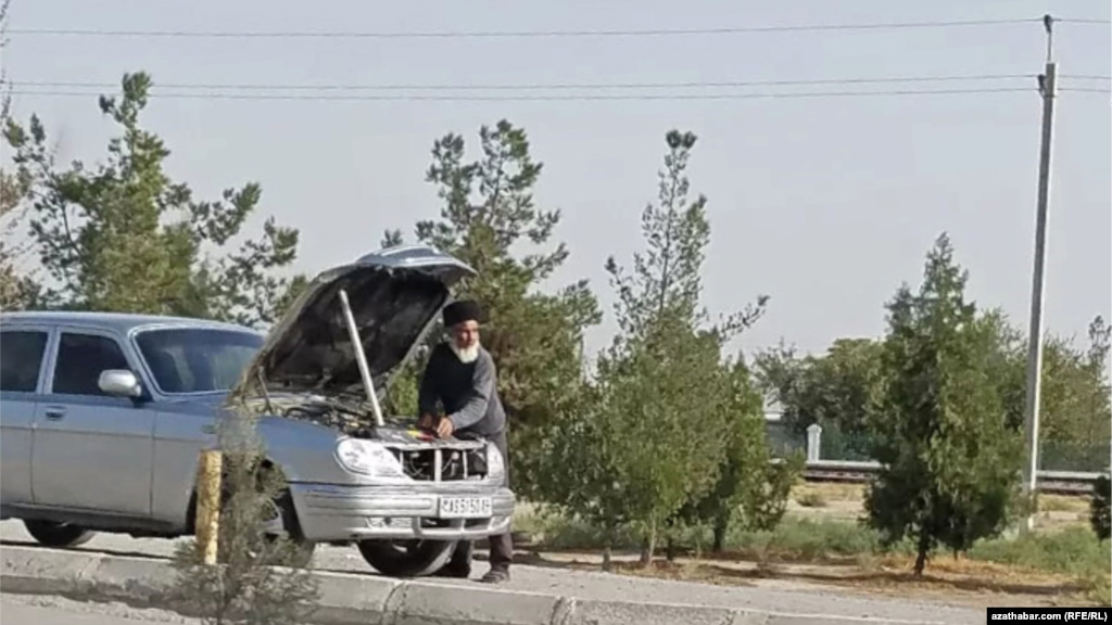 Köçede awtoulgayny bejerýän adam. Aşgabat, 2021. 