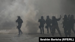Oficerë policorë mes tymit të gazit lotsjellës gjatë protestës së tensionuar.