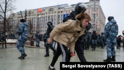 Полициски службеник приведува учесник во неовластен митинг за поддршка на рускиот опозициски активист Алексиј Навални на московскиот плоштад Пушкинскаја на 23 јануари.