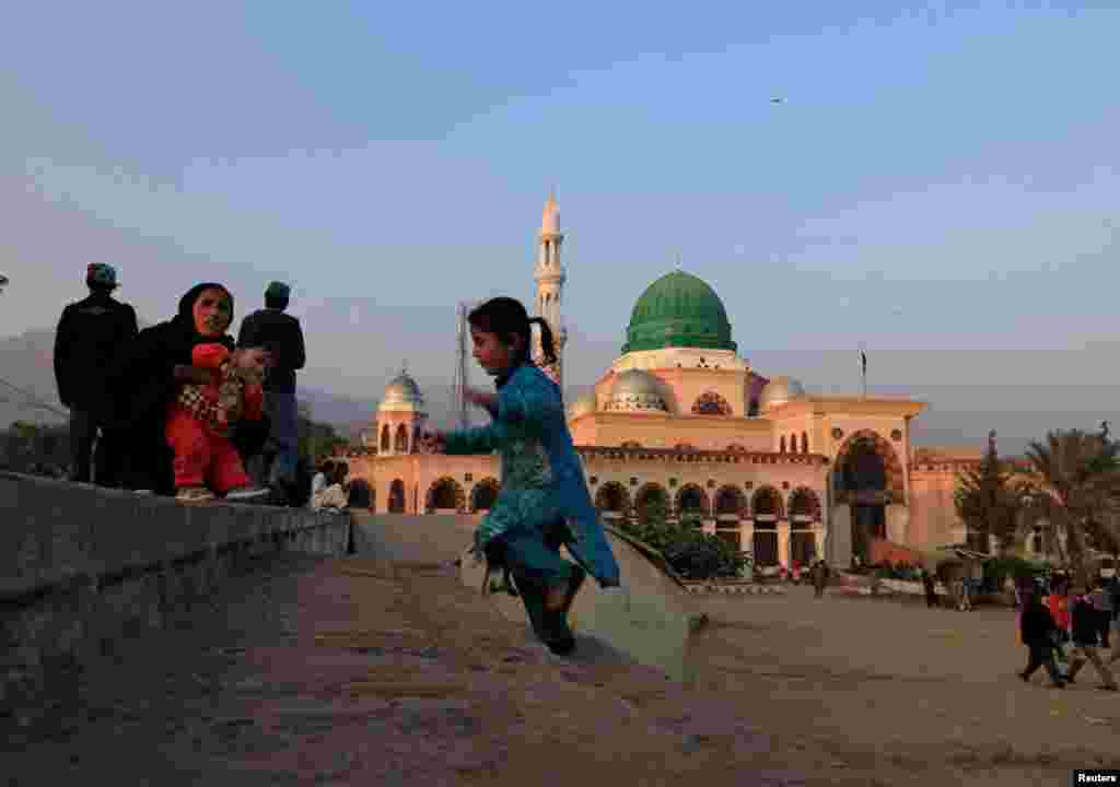 A girl plays near her mother as they visit the shrine of Bari Imam in Islamabad, Pakistan. (Reuters/Faisal Mahmood)