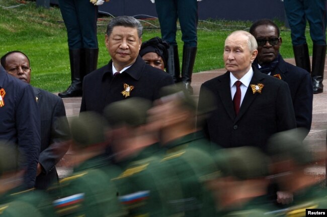 Президент Росії Володимир Путін та президент Китаю Сі Цзіньпін спостерігають за маршем російських військовослужбовців з нагоди 80-ї річниці перемоги над нацистською Німеччиною у Другій світовій війні в Москві, Росія, 9 травня 2025 року