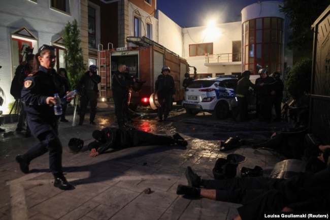 Një polic i plagosur shihet i shtrirë në tokë gjatë protestës antiqeveritare të 18 tetorit në Tiranë.