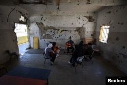 „Amit én itt csinálok, az az, hogy boldoggá teszem a gyerekeket a zenével, mert ez az egyik legjobb módja az érzések kifejezésének” - mondja a 32 éves gitártanár, Mohammed Abu Mahadi