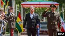 Bolivian Defense Minister Edmundo Novillo is greeted by Iran's then-defense minister Mohammad-Reza Ashtiani in Tehran in July 2023.