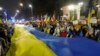 Participants carry a giant Ukrainian flag to mark the one-year anniversary of the Russian invasion of Ukraine in front of the Russian Embassy in Warsaw on February 24. 