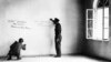 FILE - In this June 14, 1945 file photo a couple of American soldiers write their names on the wall of the bedroom where Adolf Hitler was born in Braunau, Austria.