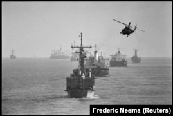 A helicopter follows a US naval convoy of tankers through the Persian Gulf in June 1988.