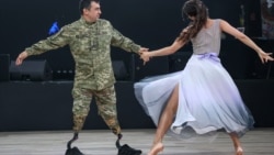Украинский солдат Артем танцует со своей подругой Полиной на благотворительном балу "Смелые сердца" в Киеве 31 мая. "С одной стороны, это очень просто, – говорит военнослужащий, описывая свое умение танцевать после частичной ампутации обеих ног, – с другой стороны, физически очень сложно. Но нужно мечтать, ставить цели, двигаться дальше и своим примером доказывать, что нет ничего невозможного".<br><br>Снимок Сергея Нужненко, корреспондента украинской службы Радио Свобода.