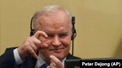 Sfidător de la început, până la sfârșit: Mladic s-a prefăcut că le face poze jurnaliștilor din sala de tribunal de la Haga, la pronunțarea verdictului final, pe 8 iunie.