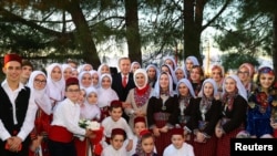 Turkish President Recep Tayyip Erdogan and his wife Emine (center) pose with members of the Muslim community in Komotini, Greece, on December 8. 