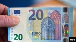 Germany --An employee of the German Federal Bank (Bundesbank) holds up a new 20 euro note in Duesseldorf, 04 November 2015. 