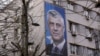 Një baner i ish-presidentit të Kosovës, Hashim Thaçi, në murin e një ndërtese në Prishtinë.