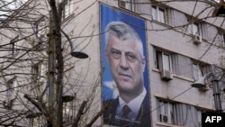 Një baner i ish-presidentit të Kosovës, Hashim Thaçi, në murin e një ndërtese në Prishtinë.