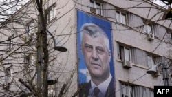 Transparent sa fotografijom bivšeg predsjednika Kosova Hashima Thaçija na zidu zgrade u Prištini.