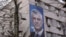 Transparent sa fotografijom bivšeg predsjednika Kosova Hashima Thaçija na zidu zgrade u Prištini.