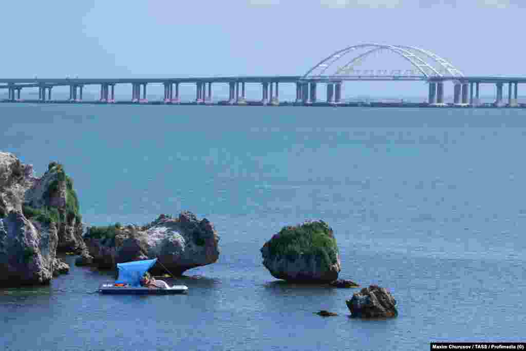 Holidaymakers seen in front of the Kerch Bridge on June 12.Following the June 20-21 strikes, traffic on the bridge connecting Russia and Crimea was reportedly shut down.