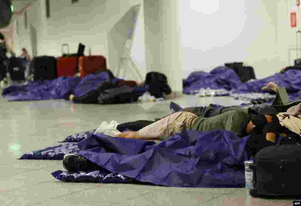 Пассажиры спят на надувных матрасах на земле в Международном аэропорту Мюнхена, Германия, 4 октября 2025 года, после того как сообщения об обнаружении беспилотников вновь заставили закрыть аэропорт и отменить более 30 рейсов.