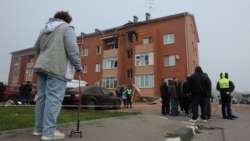 People gather outside a damaged residential building following a Ukrainian drone strike in the Ramensky district of the Moscow region.